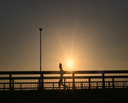 Happy athletic woman jogging in morning sun